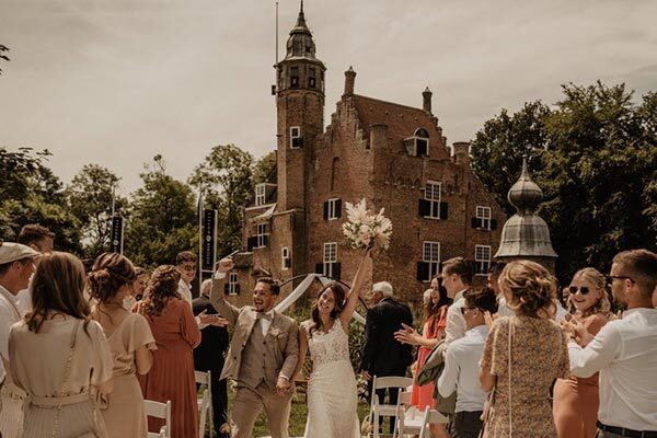Bruidspaar voor de trouwlocatie in Renesse, Slot Moermond